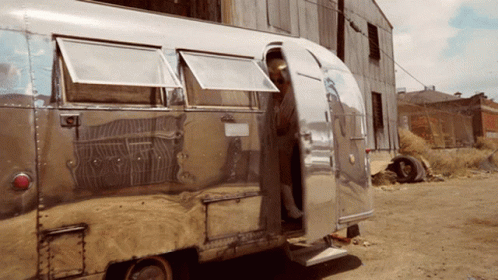 A Silver Airstream Trailer Is Parked In A Dirt Lot GIF
