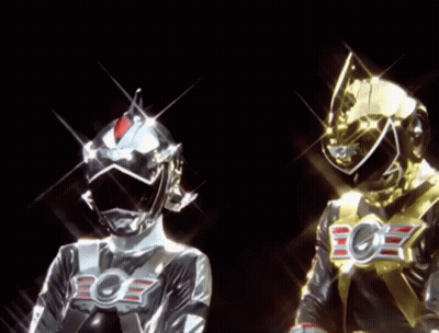 A Silver And A Gold Superhero With The Letter E On Their Chest GIF