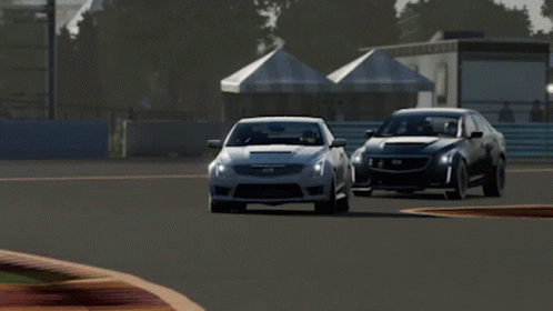 A Silver Cadillac Driving On A Race Track GIF