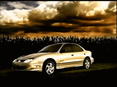 A Silver Car Is Parked In A Field With A Cloudy Sky Behind It GIF