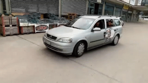 A Silver Car With A Sticker On The Door That Says ' T-Shirt ' On It GIF