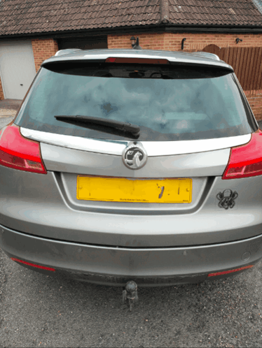 A Silver Car With A Yellow License Plate Number 7 GIF
