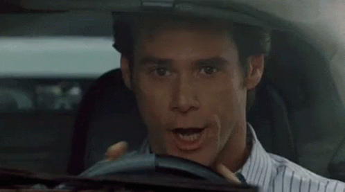 A Silver Car With The Word Allen On The Back Is Driving Down A Street GIF