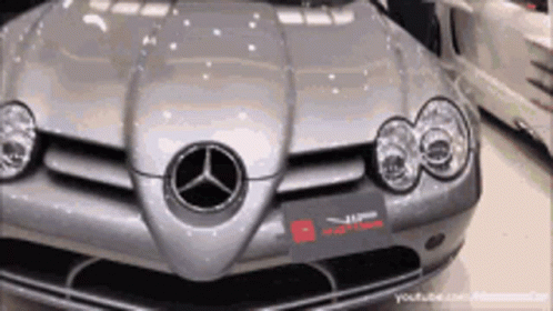 A Silver Mercedes Is Parked In A Garage With Other Cars GIF