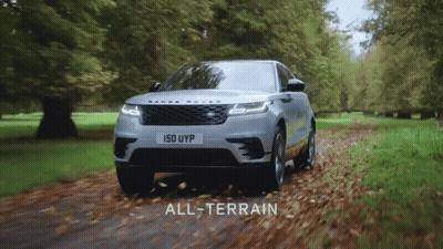 A Silver Range Rover Is Driving Down A Road With Leaves On The Ground GIF