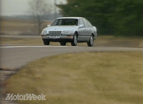 A Silver Sedan With A License Plate That Says Senator Cc Is Driving Down A Road GIF