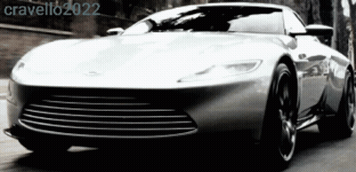 A Silver Sports Car Is Driving Down A Road With The Year 2022 On The Bottom Right GIF