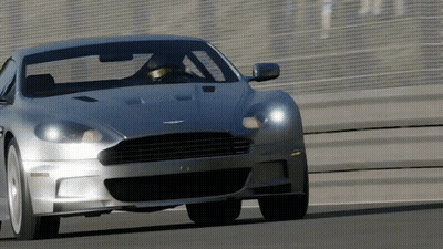 A Silver Sports Car Is Driving On A Road GIF