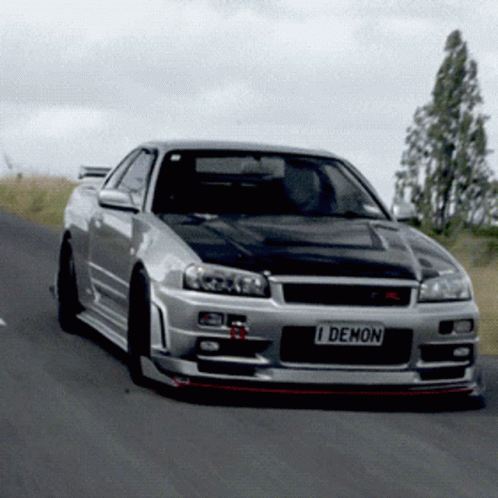 A Silver Sports Car With A License Plate That Says I Demon GIF