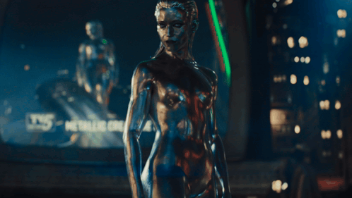 A Silver Statue Of A Woman With A Blue Eye GIF