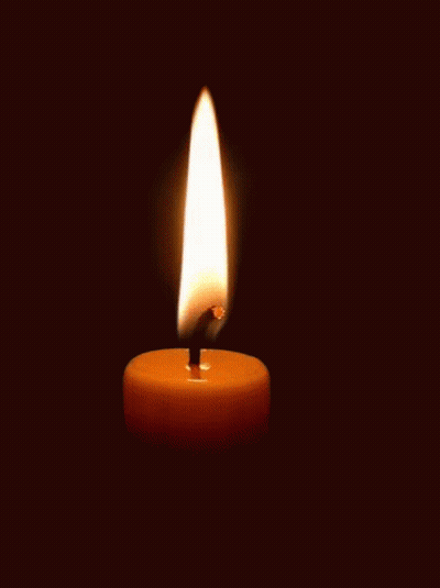 A Single Candle Is Lit In The Dark With A Black Background GIF
