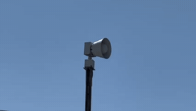A Siren Is Sitting On Top Of A Pole In The Sky . GIF
