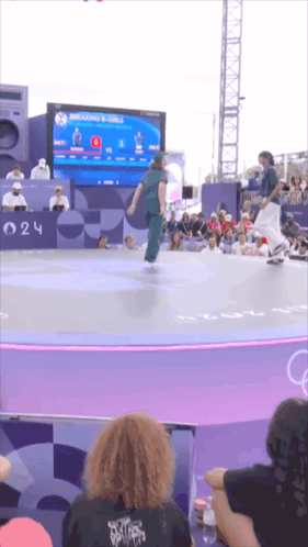 A Skateboarder Is Doing A Trick In Front Of A Crowd At A Competition GIF