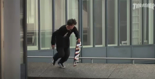 A Skateboarder Is Doing A Trick On A Railing While Holding A Skateboard . GIF