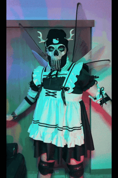 A Skeleton Dressed As A Maid With Wings And A Knife GIF