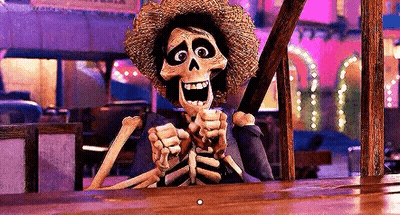 A Skeleton In A Straw Hat Is Sitting At A Table Holding A Stick . GIF