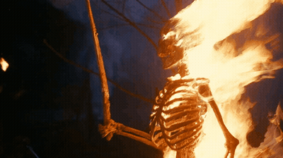 A Skeleton Is Burning In The Dark With Flames Coming Out Of It GIF