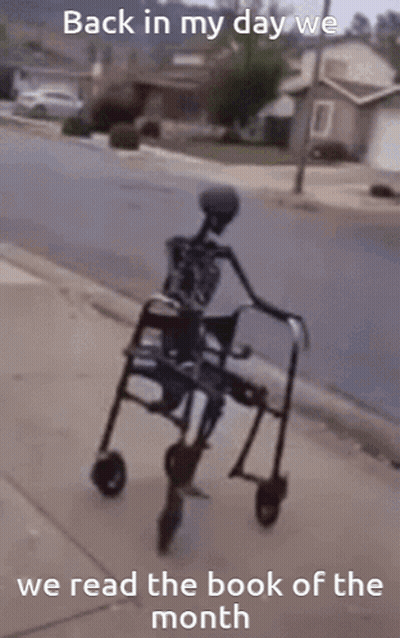 A Skeleton Is Riding A Walker Down A Sidewalk With The Words Back In My Day We Read The Book Of The Month GIF