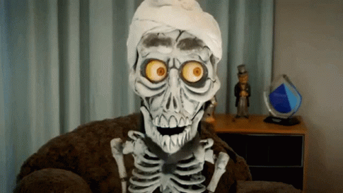 A Skeleton Is Sitting In A Chair With A Bandaged Head GIF