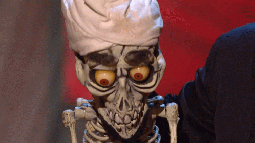 A Skeleton Wearing A Chef 'S Hat Is Being Held By Someone GIF