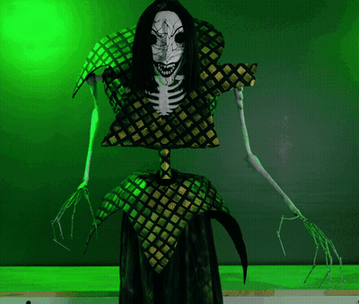 A Skeleton With Long Black Hair And Sharp Teeth Stands In Front Of A Green Wall GIF