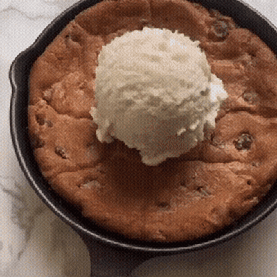A Skillet With A Cookie And A Scoop Of Ice Cream On Top GIF