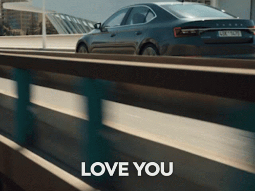 A Skoda Car Is Driving Down A Highway Next To A Sign That Says " Love You " GIF