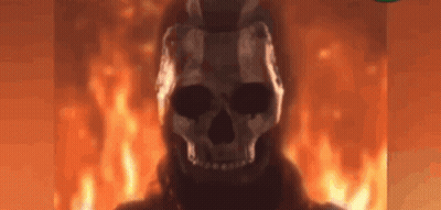 A Skull Is Standing In Front Of A Fire In A Dark Room . GIF