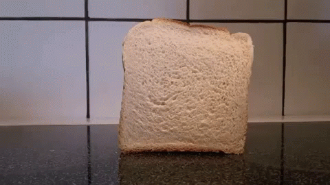 A Slice Of Bread Sits On A Counter In Front Of A White Tiled Wall GIF
