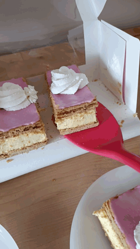 A Slice Of Cake With Pink Frosting And Whipped Cream On Top GIF