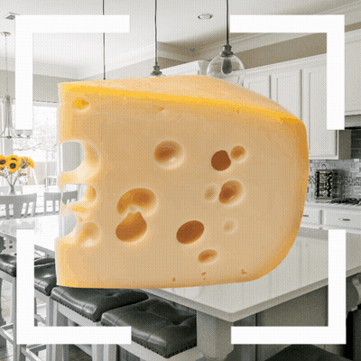 A Slice Of Cheese With Holes In It Is Hanging From The Ceiling In A Kitchen GIF