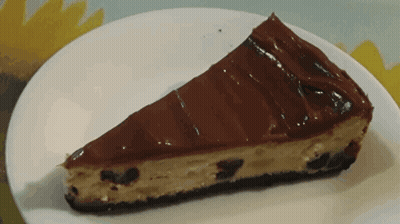 A Slice Of Cheesecake On A White Plate GIF