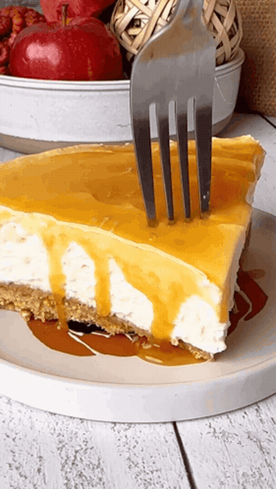 A Slice Of Cheesecake With A Fork Sticking Out Of It GIF