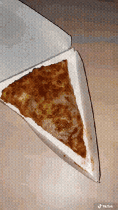 A Slice Of Pizza In A Cardboard Box With A Tiktok Watermark GIF