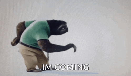A Sloth Wearing A Green Shirt And Khaki Pants Is Walking With A Cane And Says `` Im Coming '' . GIF