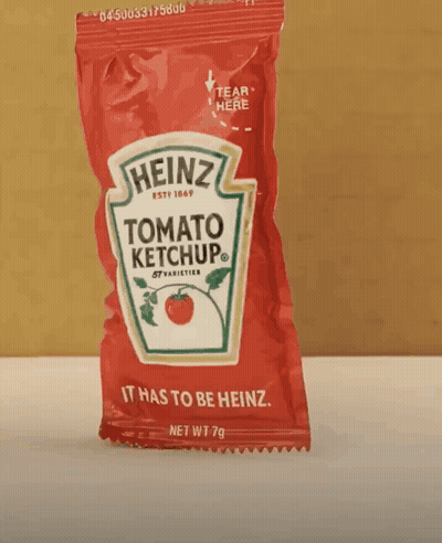 A Small Bag Of Heinz Tomato Ketchup Is Sitting On A Table GIF
