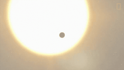 A Small Planet Is Moving In Front Of A Large White Star GIF