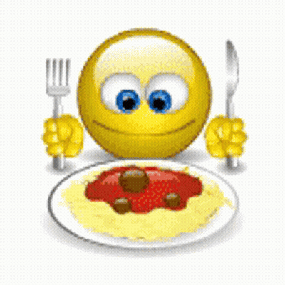 A Smiley Face Is Holding A Fork And Knife In Front Of A Plate Of Spaghetti And Meatballs . GIF