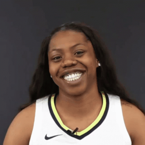 A Smiling Woman Wearing A White Nike Shirt GIF