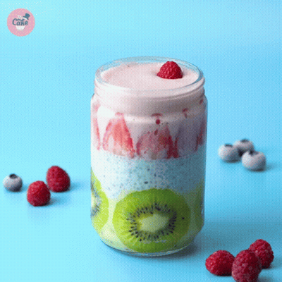 A Smoothie In A Jar With Raspberries And Kiwi On Top GIF