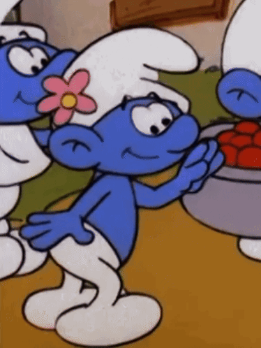A Smurf With A Pink Flower On His Head Holds A Bowl Of Tomatoes GIF