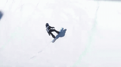 A Snowboarder Is Doing A Trick In Front Of A Fence That Says Stanley On It GIF