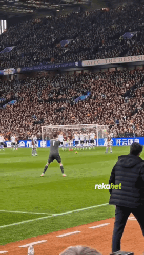 A Soccer Game Is Being Played In A Stadium With A Sign That Says Live The Obsession GIF
