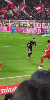 A Soccer Game Is Being Played In Front Of A Magenta Tv Sign GIF