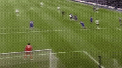 A Soccer Game Is Being Played On A Field And A Goalie Is Diving To Save A Goal . GIF