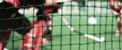 A Soccer Game Is Being Played On A Field Behind A Fence GIF