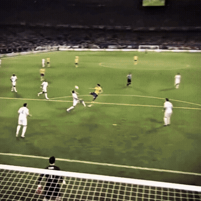 A Soccer Game Is Being Played On A Field With Players In White And Yellow GIF