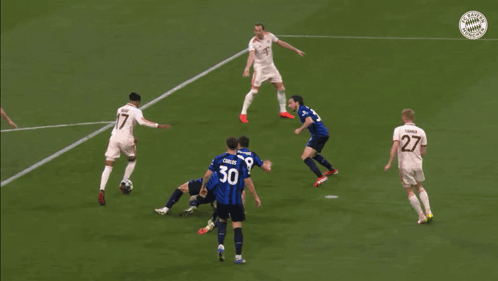 A Soccer Goalie Dives To Catch A Soccer Ball In Front Of A Bayern Logo GIF