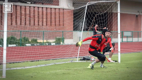 A Soccer Goalie In A Red Jersey With Fly Emirates Written On It GIF