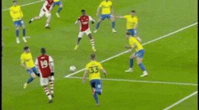 A Soccer Goalie Is Diving To Catch A Soccer Ball On A Field . GIF